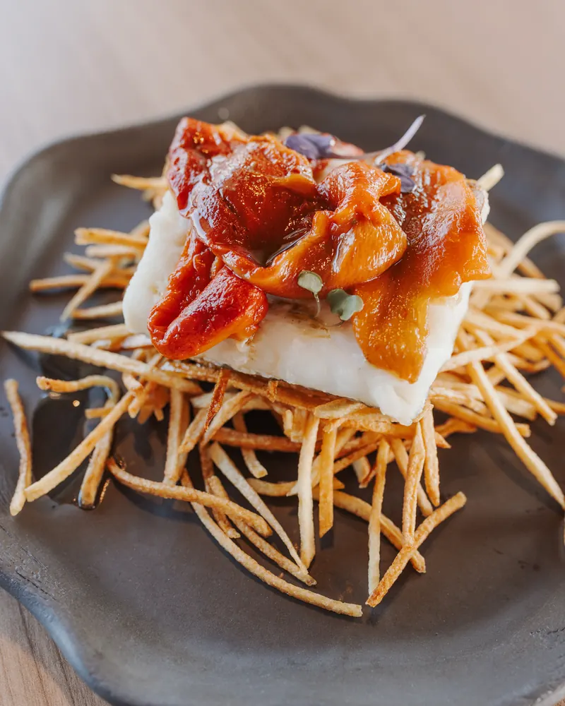 Bacalao con pimientos asados y patata paja